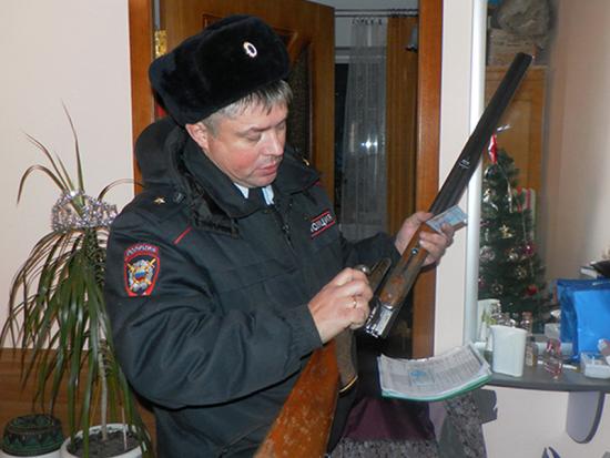 сотрудник полиции проверяет условия хранения ружья